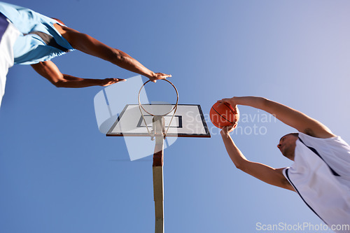 Image of Men, player and basketball game at outdoor court or low angle of challenge team, dunk on rival. Male people, hoop or score point in summer park on fitness match or competition, athlete at blue sky