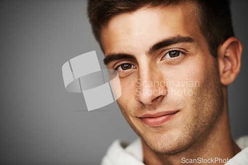 Image of Portrait, man and closeup for fashion in studio for mock up in cool, casual and style on gray background. Male model, person or student with facial expression with confidence with hoodie in Spain