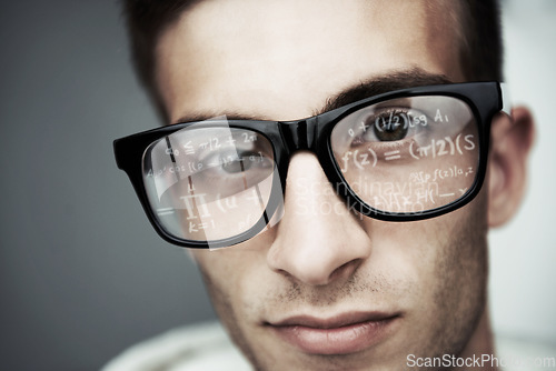 Image of Portrait, glasses and formula with a man programmer closeup in studio on a gray background for support. Face, eyewear and software development with a young nerd or geek reading coding data or info