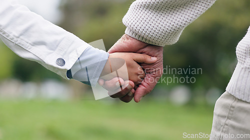 Image of Holding hands, closeup and park with father, child and walking with bonding, love and security in nature. Dad, kid and safety with trust, care and support for holiday, freedom or adventure together