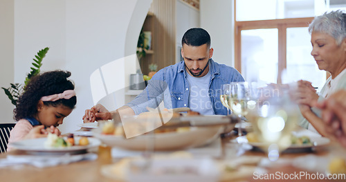 Image of Christian, family and praying at dinner in home with gratitude, thanks and praise for God. People, pray and together giving spiritual respect or grace at lunch, table and holding hands in dining room