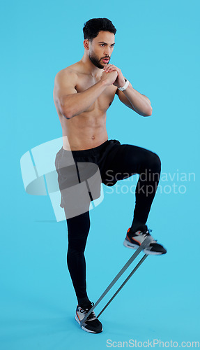 Image of Man, legs and resistance band in fitness, workout or training against a blue studio background. Male person, athlete or serious model with straps for cardio exercise, endurance or stamina on mockup