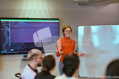 Image of A pregnant business woman with orange hair confidently presents her business plan to colleagues in a modern glass office, embodying entrepreneurship and innovation