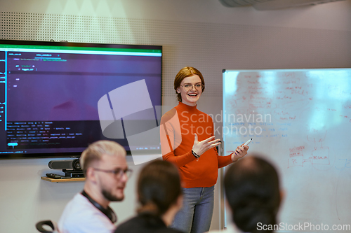 Image of A pregnant business woman with orange hair confidently presents her business plan to colleagues in a modern glass office, embodying entrepreneurship and innovation