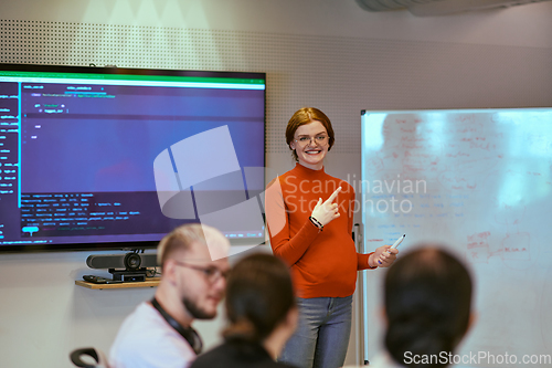 Image of A pregnant business woman with orange hair confidently presents her business plan to colleagues in a modern glass office, embodying entrepreneurship and innovation