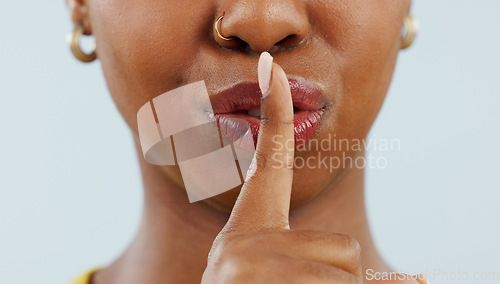 Image of Black woman, mouth and lips in secret for gossip, privacy or confidential information against a studio background. Closeup of African female person with finger or emoji in silence, quiet or whisper