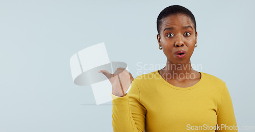 Image of Surprise, news and portrait of black woman with hand pointing in studio for wow announcement on grey background. Emoji, face and African model show unexpected results, giveaway or secret promotion