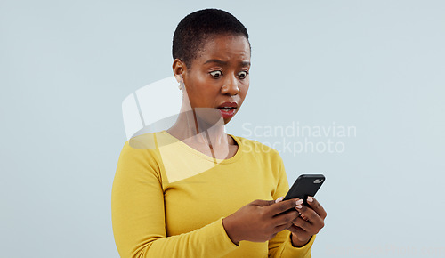 Image of Black woman, phone and shocking news on social media, terrifying or online against a studio background. Face of surprised African female person or model on mobile smartphone for alert notification