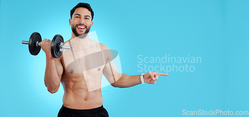 Image of Gym, portrait and happy man with dumbbell or hand pointing to studio for fitness, promo or info on blue background. Face, smile and male bodybuilder show sign up, presentation or membership offer