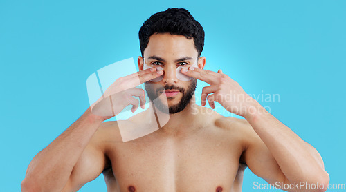 Image of Skincare, portrait and man with eye patches for anti ageing treatment isolated on blue background. Care, skin and face of model with collagen mask on eyes, dermatology and luxury spa facial in studio