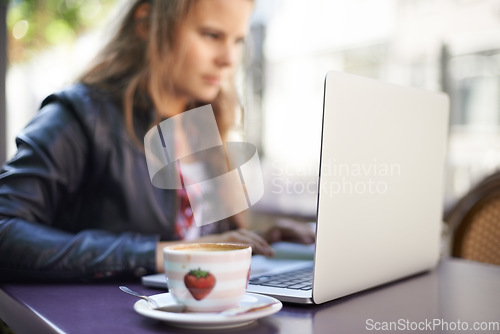 Image of College student, working and laptop outdoor at coffee shop, cafe or restaurant with espresso, latte or cup. Girl, studying and drink a green tea or beverage in summer, morning or bistro on campus