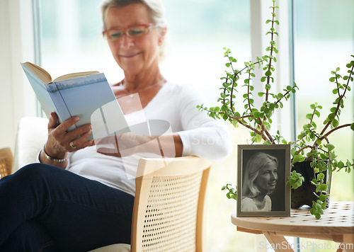 Image of Senior, woman and relaxing with book in home for reading, wellness or self care. Elderly person, glasses and smile with happiness for resting, peace or retirement with vintage photograph for memory