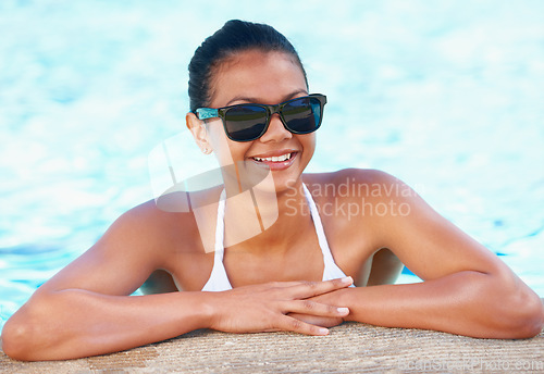 Image of Woman, swimming pool and smile with summer, sunglasses and tourism to relax in water on vacation. Girl, outdoor and bikini with glasses, freedom and sunshine with fashion on holiday in Indonesia