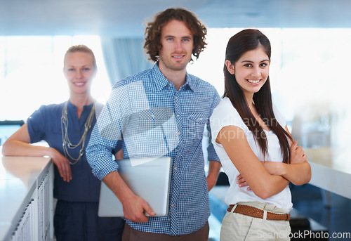 Image of Portrait, collaboration and a business team in the office on a mission for growth or company development together. Smile, laptop and arms crossed with a designer group in an agency workplace