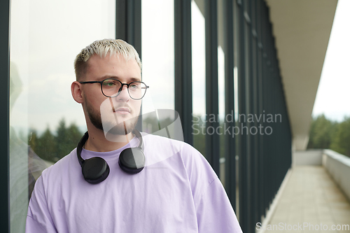 Image of In front of a modern glass building, a young, blond influencer strikes a confident pose, epitomizing urban glamour and style in the heart of the city