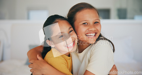 Image of Siblings, portrait and sisters hug in home with love, care and kids with support on sofa in living room. Happy, face and children bonding in embrace together on couch in lounge of apartment or house
