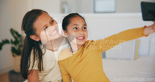 Image of Selfie, sister and happy with girl children in the bedroom of their home together for a social media profile picture. Family, smile and sibling kids on a bed in their apartment to update a status