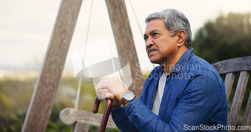 Image of Senior, man or thinking with cane for retirement, alzheimer and memory outdoor on bench and lonely. Elderly, person or walking stick with nostalgia, thoughtful and peace in nature or park with wonder