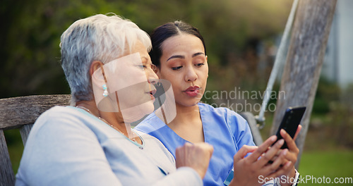 Image of Outdoor, bench and nurse with old woman, smartphone and connection with social media, conversation and internet. Pensioner, outdoor and caregiver with elderly person, cellphone and typing with email