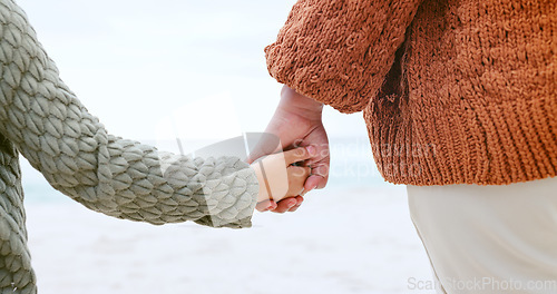 Image of Parent, child and holding hands at ocean for love, care or support in trust, travel or outdoor getaway. Closeup of person with kid for unity, bonding or compassion on beach or sea coast together