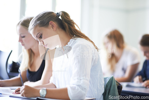 Image of College student, writing and learning with notes in class, lecture or people in education. University, classroom and exam or test on campus with knowledge or studying a course in academy or school