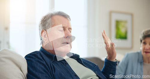 Image of Senior, couple or stress with conflict and fight on sofa in living room of home with hand for stop. Elderly, man or woman with argument, upset and frustrated on couch in lounge of house or ignore