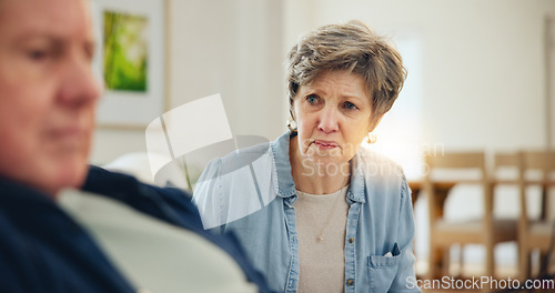 Image of Senior, couple and stress with conflict and divorce on sofa in living room of home with anger and silence. Elderly, man or woman with fight, upset and frustrated on couch in lounge of house or ignore