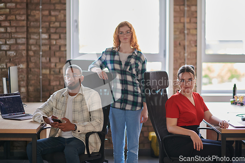 Image of A diverse group of young business individuals congregates in a modern startup coworking center, embodying collaborative innovation and a dynamic atmosphere.