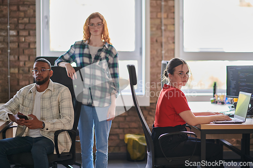 Image of A diverse group of young business individuals congregates in a modern startup coworking center, embodying collaborative innovation and a dynamic atmosphere.