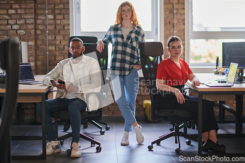 Image of A diverse group of young business individuals congregates in a modern startup coworking center, embodying collaborative innovation and a dynamic atmosphere.