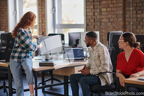 Image of A diverse group of young business individuals congregates in a modern startup coworking center, embodying collaborative innovation and a dynamic atmosphere.