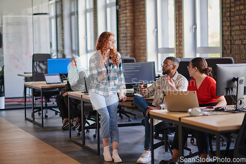 Image of A diverse group of young business individuals congregates in a modern startup coworking center, embodying collaborative innovation and a dynamic atmosphere.