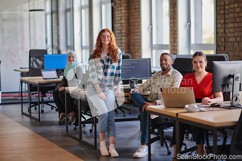 Image of A diverse group of young business individuals congregates in a modern startup coworking center, embodying collaborative innovation and a dynamic atmosphere.