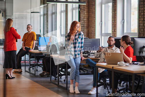 Image of A diverse group of young business individuals congregates in a modern startup coworking center, embodying collaborative innovation and a dynamic atmosphere.