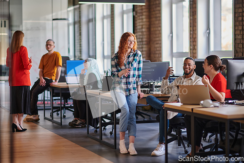 Image of A diverse group of young business individuals congregates in a modern startup coworking center, embodying collaborative innovation and a dynamic atmosphere.