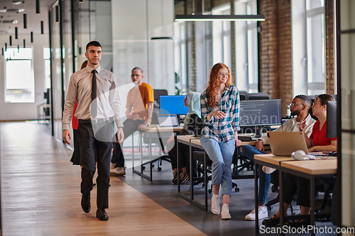 Image of A diverse group of young business individuals congregates in a modern startup coworking center, embodying collaborative innovation and a dynamic atmosphere.