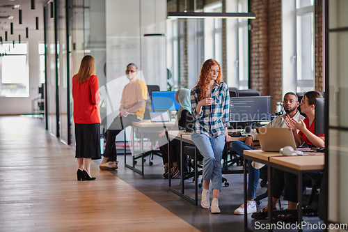 Image of A diverse group of young business individuals congregates in a modern startup coworking center, embodying collaborative innovation and a dynamic atmosphere.
