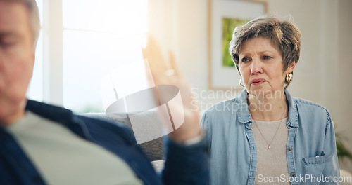 Image of Senior, couple and divorce with conflict and fight on sofa in living room of home with hand for stop. Elderly, man and woman with argument, upset and frustrated on couch in lounge of house or ignore