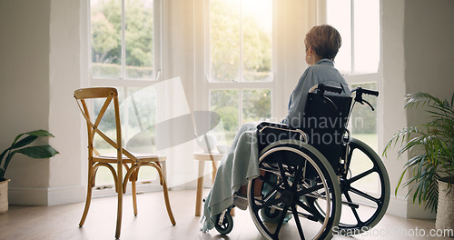 Image of Wheelchair, old woman or thinking and lonely by window in nursing home or retirement with depression. Nostalgia, sad memory or depressed elderly person in lounge by an empty chair to remember past