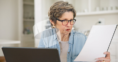 Image of Senior woman, laptop and documents for finance, budget planning or expenses in living room at home. Mature female person busy with paperwork on computer for financial investment, bills or mortgage