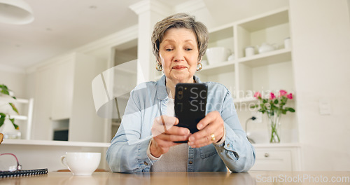 Image of Senior woman typing on smartphone in home at table for social media, reading email or chat. Elderly person on mobile phone app, search internet and communication on digital technology in retirement