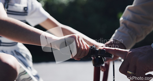 Image of Parent, child and teaching bicycle ride for safety, closeup and outdoor street with hands. Cycling, childhood memory and riding in summer, bonding together and recreation with bike bell for alert