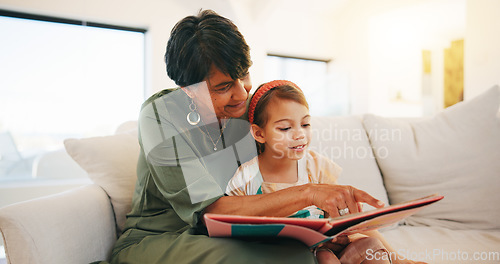 Image of Grandmother, child and reading book on sofa for literature, education or bonding together at home. Grandparent with little girl or kid smile for story, learning or relax on living room couch at house