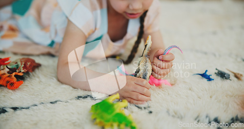 Image of Girl child, dinosaur toys and floor with playing, development and relax with game in room at family house. Kid, plastic reptile and carpet with hands, flooring or animal for fantasy, learning or home