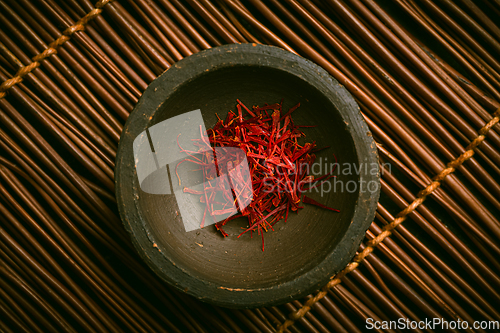 Image of Saffron threads in a small bowl. Spices, cooking ingredients, flavor.