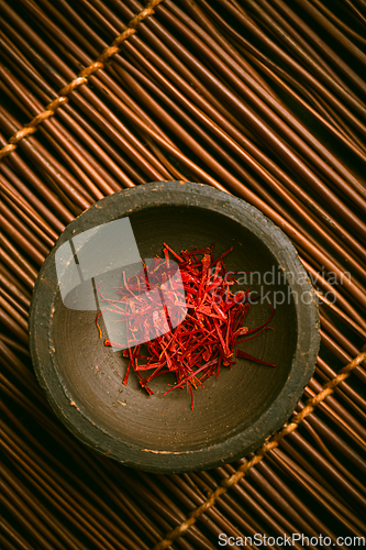 Image of Saffron threads in a small bowl. Spices, cooking ingredients, flavor.