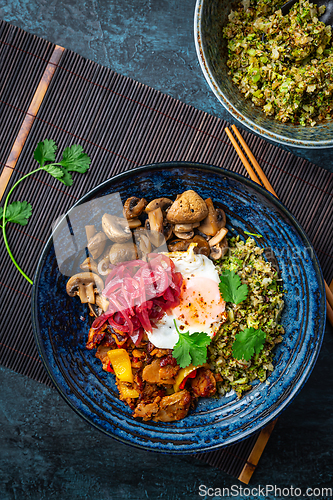 Image of Ketogenic diet bowl with organic cauliflower and broccoli rice, stir fried chicken, mushrooms, egg and onions