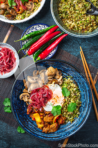 Image of Ketogenic diet bowl with organic cauliflower and broccoli rice, stir fried chicken, mushrooms, egg and onions