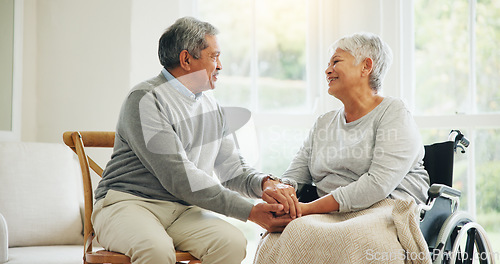 Image of Love, retirement and an old woman in a wheelchair with her husband in the living room of their home together. Trust, support and an elderly man talking to his wife with a disability in the apartment