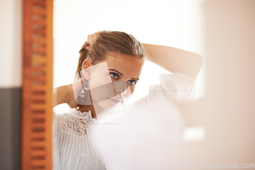 Image of Hair, care and teenager in morning with mirror and tying a ponytail hairstyle for school. College student, beauty and reflection of girl, face and style in home, apartment or preparation in bedroom